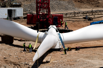 A wind turbine's rotor being lifted by crane.